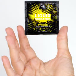SecretPlay Vibratorflüssigkeit freistehend neben der Produktverpackung
