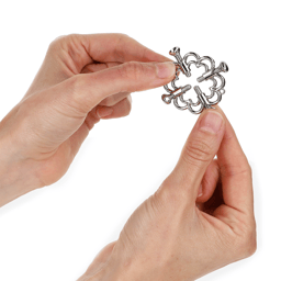 Blütenmotiv der Kink Nippelklemmen aus der Nähe, Metalloberfläche im Detail